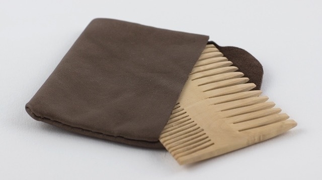 A hand made nit comb in a leather pouch