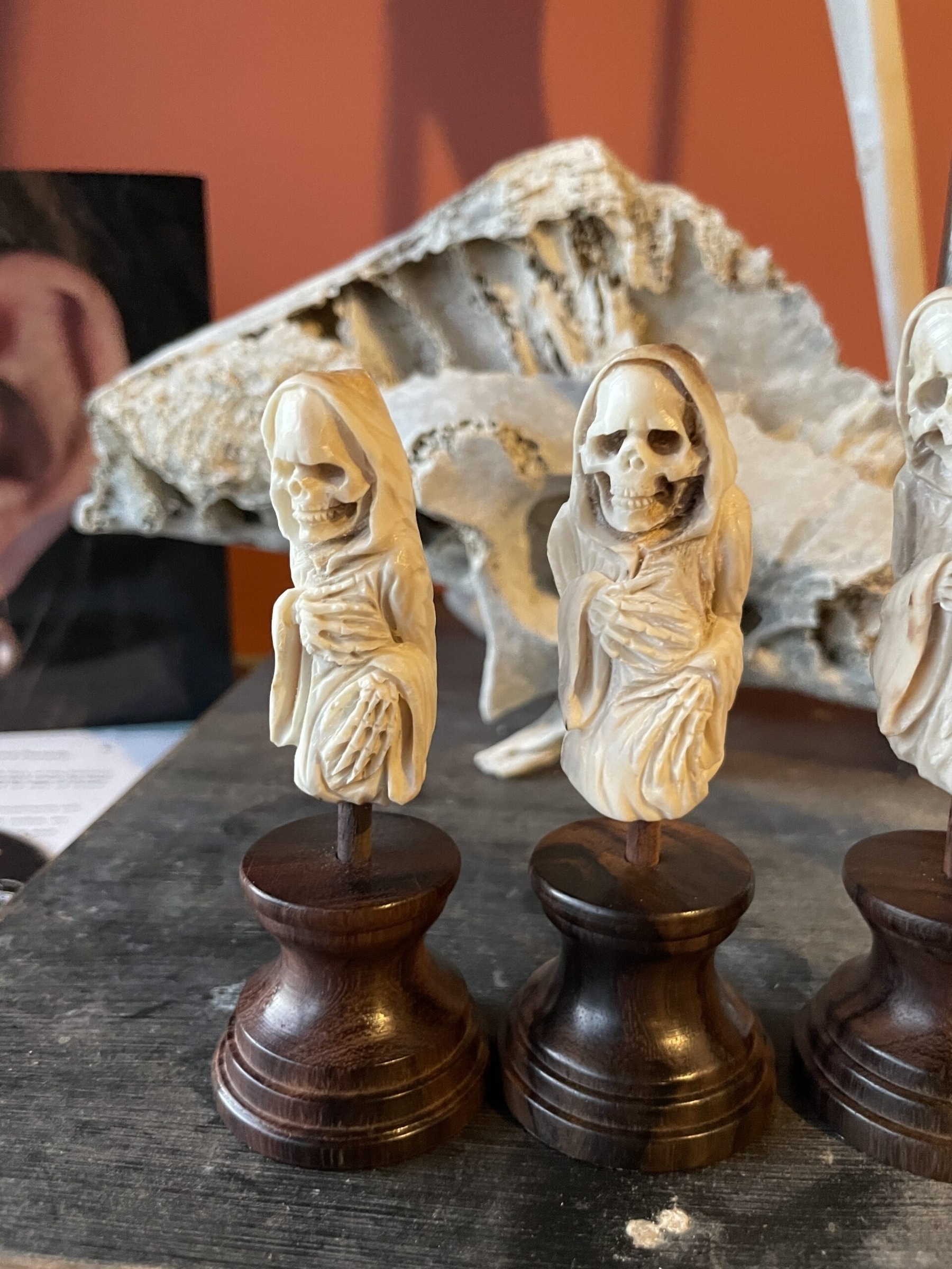 A couple of death figurines standing on dark wooden plinths