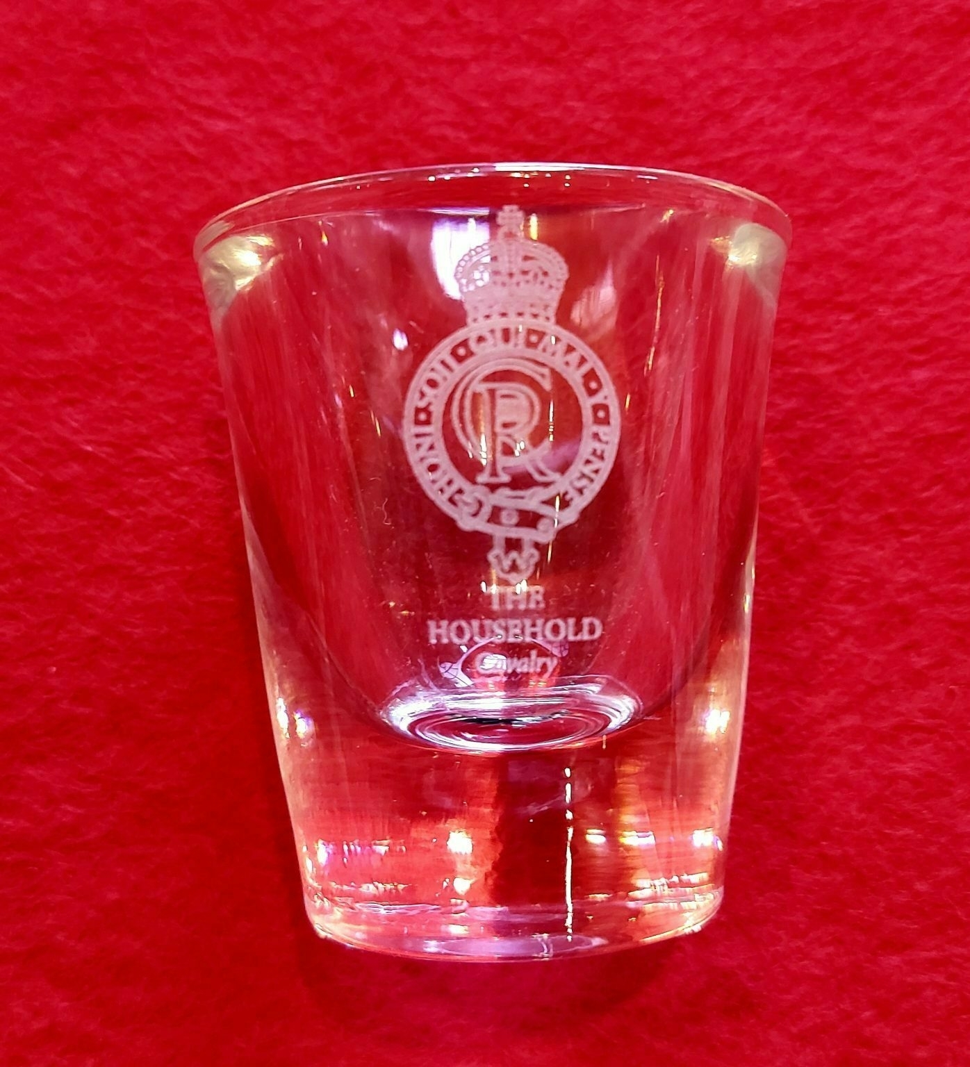 A glass shotglass with King Charles' cypher